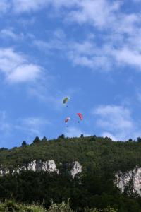 three kites flying in the sky over a mountain at Domaine Saint Esteve in Millau