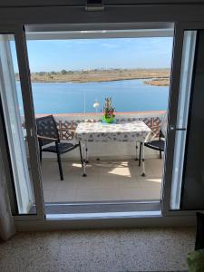 a table and chairs on a balcony with a view of the water at Appartement Vue mer et Parc naturel in Roses