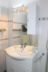 a bathroom with a white sink and a mirror at "Appartement 6 - Feriennest" - ab sofort mit W-LAN in Grömitz