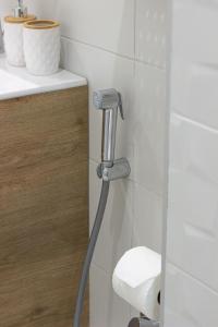 a bathroom with a toilet paper dispenser on a wall at Grand Relax Cape Cod by RV Apartments in Varna City +32 photos