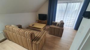a living room with two couches and a table and a television at Apartmány Semily in Semily