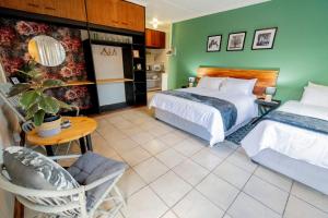 Habitación de hotel con 2 camas, mesa y silla en Mulkana, en Bloemfontein
