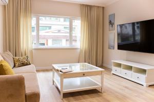 a living room with a couch and a tv at Grand Relax Cape Cod by RV Apartments in Varna City