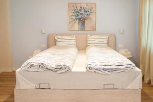 a bed with two pillows on it in a bedroom at Grand Relax Cape Cod by RV Apartments in Varna City