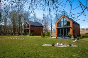 a barn conversion with glass windows and a green yard at Zielone Wrzosowisko in Świętajno