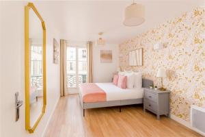 ein Schlafzimmer mit einem Bett und einem großen Spiegel in der Unterkunft Cosy 4 Bedrooms 2 Bathr Apartment - Champs Elysées in Paris