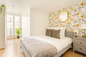 Schlafzimmer mit einem Bett mit Blumentapete in der Unterkunft Cosy 4 Bedrooms 2 Bathr Apartment - Champs Elysées in Paris