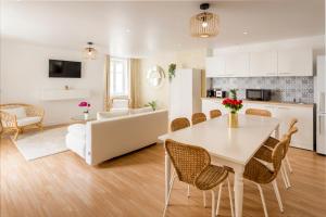 eine Küche und ein Wohnzimmer mit einem weißen Tisch und Stühlen in der Unterkunft Cosy 4 Bedrooms 2 Bathr Apartment - Champs Elysées in Paris