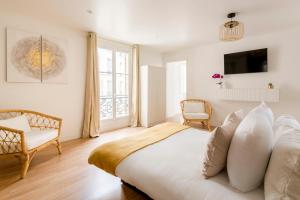 ein weißes Schlafzimmer mit einem Bett und einem Fenster in der Unterkunft Cosy 4 Bedrooms 2 Bathr Apartment - Champs Elysées in Paris