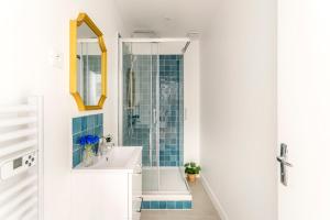 ein Badezimmer mit einem weißen Waschbecken und einer Dusche in der Unterkunft Cosy 4 Bedrooms 2 Bathr Apartment - Champs Elysées in Paris