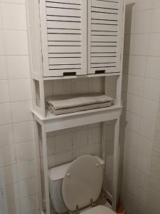 La salle de bains est pourvue de toilettes blanches et d'une fenêtre. dans l'établissement Chambre indépendante - style studio - avec jardin à la campagne, à Junhac