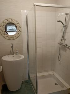 La salle de bains est pourvue d'une douche et d'un lavabo. dans l'établissement Chambre indépendante - style studio - avec jardin à la campagne, à Junhac