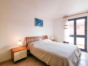 1 dormitorio con cama y ventana en Cala Francese Apartments, en Capo Testa