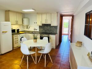 a kitchen with a white table and white chairs at Apartamento Rabdells Olivanova 150m de la playa in Oliva