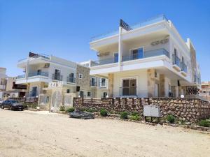 a large white house with a stone wall at Boka Bay One in Hurghada