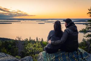 a couple sitting on a rock watching the sunset at Break Sokos Hotel Koli in Kolinkylä