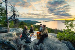 a group of people sitting around a table on a rock at Break Sokos Hotel Koli in Kolinkylä +100 photos