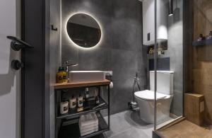 a bathroom with a sink and a toilet and a mirror at Shades of gray - NEW DELUX Apartments in Kyiv
