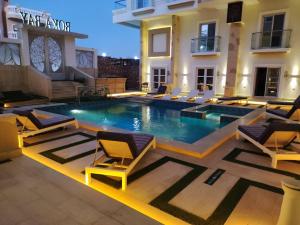 einen Pool mit Stühlen und ein Gebäude in der Unterkunft Boka Bay One in Hurghada