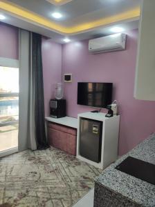 a room with a kitchen with a tv and a counter at Boka Bay One in Hurghada
