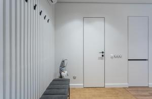 a room with white walls and a chair and two doors at Shades of gray - NEW DELUX Apartments in Kyiv