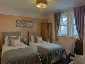 een slaapkamer met 2 bedden en een raam bij Kingsholm Guest House in Torquay