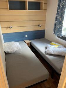 Säng eller sängar i ett rum på MobileHome 8 Personnes avec Clim situé au Camping l'Elysée Grau du roi Vagues Océanes By CapFun