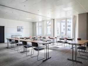 a large room with tables and chairs and windows at ibis Paris porte de Bercy in Charenton-le-Pont