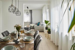 a dining room with a table and chairs and a living room at Ajko Homes - Design Apartment - Parkplatz - Balkon - Netflix - 6 Pers in Walldorf