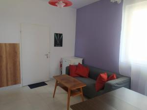 a living room with a couch and red pillows at Holiday Apartment in Badacsonytördemic