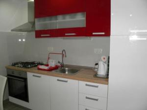 a kitchen with red cabinets and a sink at Apartman Modric Draga in Mošćenička Draga