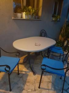 a table and two blue chairs and a table and chairs at Apartman Modric Draga in Mošćenička Draga