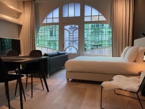 a bedroom with a bed and a table and a couch at 3 Bedroom Art-Nouveau Apartment with Free Parking in Ghent