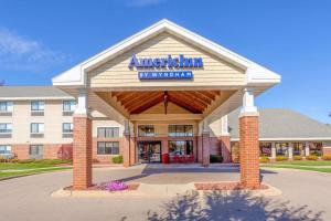 a hotel with a sign on the front of a building at AmericInn by Wyndham Madison South in Madison