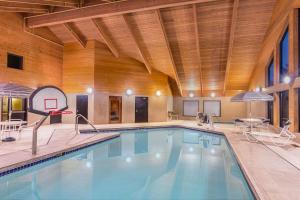 a swimming pool in a building with a wooden ceiling at AmericInn by Wyndham Madison South in Madison