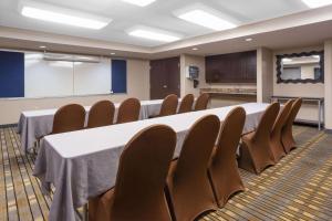 uma sala de conferências com uma mesa longa e cadeiras em AmericInn by Wyndham Madison South em Madison