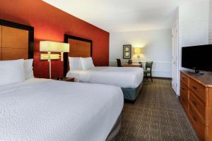 a hotel room with two beds and a flat screen tv at La Quinta Inn Tampa Airport Stadium Westshore in Tampa