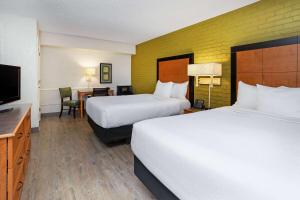 a hotel room with two beds and a flat screen tv at La Quinta Inn Tampa Airport Stadium Westshore in Tampa