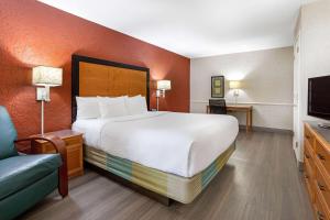 a hotel room with a large bed and a television at La Quinta Inn Tampa Airport Stadium Westshore in Tampa