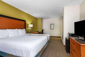 a hotel room with a bed and a flat screen tv at La Quinta Inn Tampa Airport Stadium Westshore in Tampa