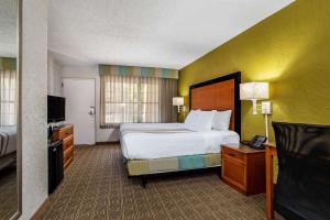 a hotel room with a bed and a television at La Quinta Inn Tampa Airport Stadium Westshore in Tampa