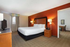 a hotel room with a bed and a television at La Quinta Inn Tampa Airport Stadium Westshore in Tampa