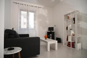 ein Wohnzimmer mit einem schwarzen Sofa und einem Tisch in der Unterkunft Casa Fea in Vietri