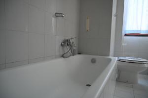 ein weißes Bad mit einer Badewanne und einem WC in der Unterkunft Casa Fea in Vietri