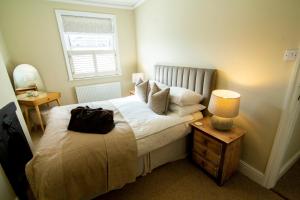 a bedroom with a bed with a bag on it at Mulberry Cottage - Cosy 3 Bed Cottage near Lytham Windmill in Lytham St Annes