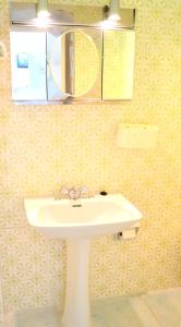 Studios LES TERRASSES de Cala Llevado في توسا ذي مار: حمام مع حوض أبيض ومرآة