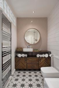 a bathroom with a sink and a toilet and a mirror at Rame Barton Guest House and Pottery in Cawsand