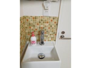 un lavandino in bagno con una bottiglia di sapone di Tokyo stay Hut SARI - Vacation STAY 27260v a Tokyo