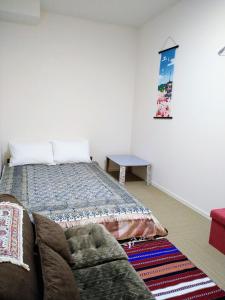 a bedroom with a bed and a couch and a table at Tokyo stay Hut SARI - Vacation STAY 27260v in Tokyo