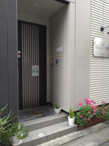 una puerta delantera de un edificio con macetas en Tokyo stay Hut SARI - Vacation STAY 27239v, en Tokio